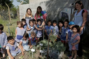 The master gardeners distribute among the boys the food they produce in the garden.