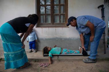 A community health assistant Mission La Paz takes size and weight measurements