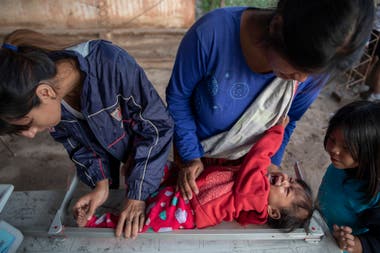 The nutritionist Elizabeth Torres, from the NGO Pata Pila, controls the size of children in the El Cañaveral community