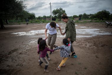 Two volunteers from the NGO Pata Pila play with children from the El Cañaveral community 1